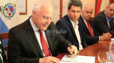 Miguel Lifschitz firma el convenio. A su lado