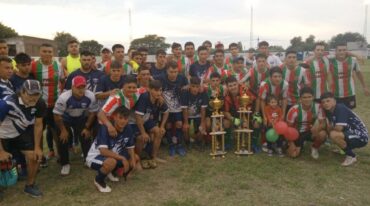 El plantel de Huracán de La Criolla posando junto a Gimnasia de Vera con las copas de campeón y subcampeón. Gentileza.