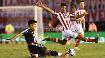 Diego Godoy (Unión) intenta tapar el despeje de Luciano Lollo (River Plate).  Télam.