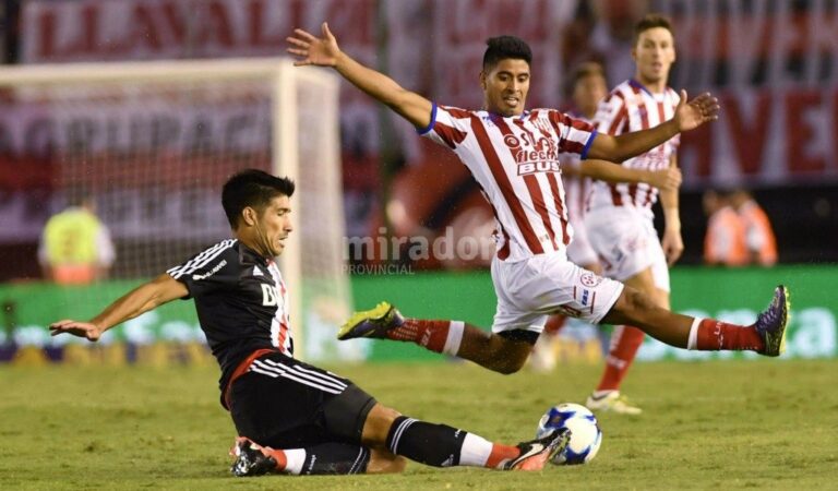 Diego Godoy (Unión) intenta tapar el despeje de Luciano Lollo (River Plate).  Télam.