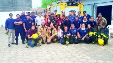 Los bomberos escoceses (agachados con sus uniformes claros) junto a los más de 25 bomberos de todos los cuarteles de la costa del Uruguay.