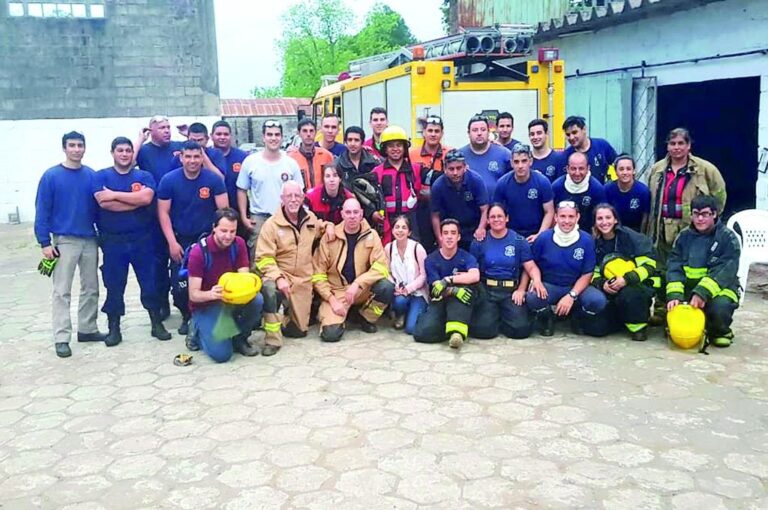Los bomberos escoceses (agachados con sus uniformes claros) junto a los más de 25 bomberos de todos los cuarteles de la costa del Uruguay.