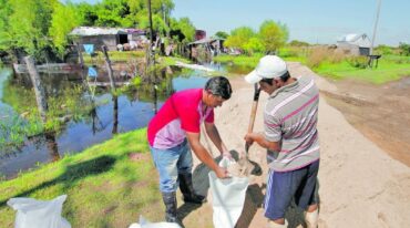 Todos a 'bolsear'. Con bolsas de arena se hacen caminos para ingresar a las viviendas. Pablo Aguirre.