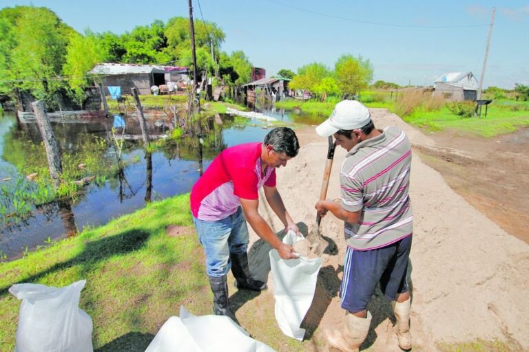 Todos a 'bolsear'. Con bolsas de arena se hacen caminos para ingresar a las viviendas. Pablo Aguirre.