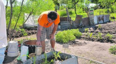 Hombres y mujeres trabajan la tierra para que crezca el alimento que pronto tendrán en el merendero barrial y en su mesa familiar.  Sergio Ruíz