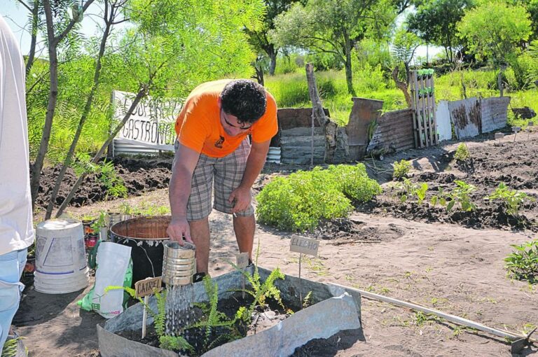 Hombres y mujeres trabajan la tierra para que crezca el alimento que pronto tendrán en el merendero barrial y en su mesa familiar.  Sergio Ruíz