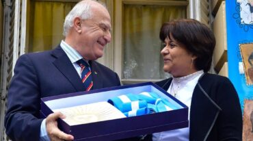 El gobernador recibió una bandera argentina de regalo de manos de la directora de la escuela