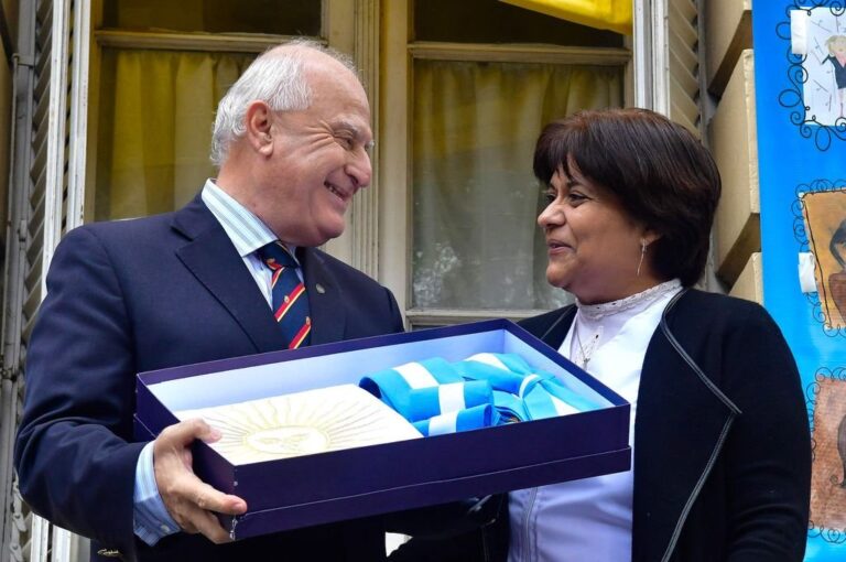 El gobernador recibió una bandera argentina de regalo de manos de la directora de la escuela