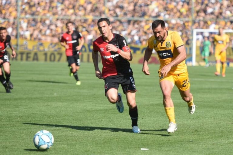Maxi Rodríguez y Fabián Rinaudo luchan por la pelota. Gentileza: prensa Rosario Central.