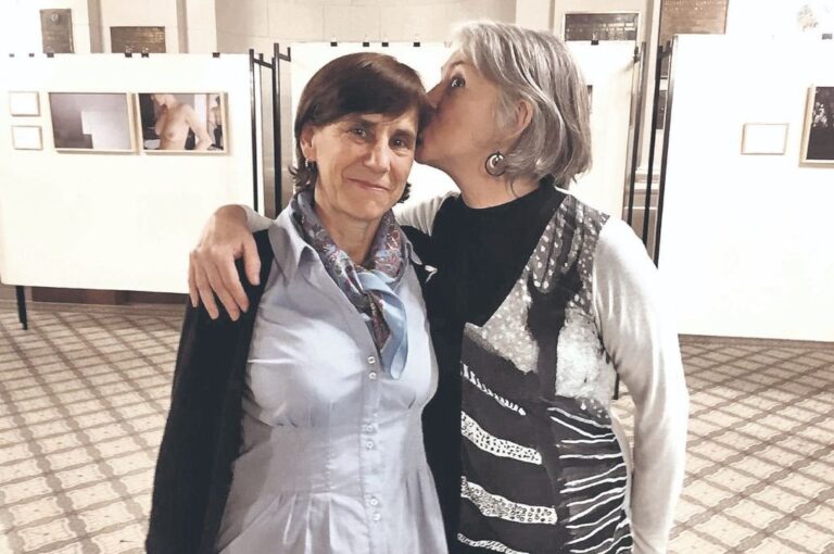 Lazos: el de color rosa para concientizar sobre la prevención del cáncer de mama en un cartel. El de amistad entre Cecilia Augsburger y Silvina Salinas