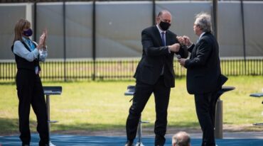 Se saludan el gobernador y el presidente; observa Alejandra Rodenas