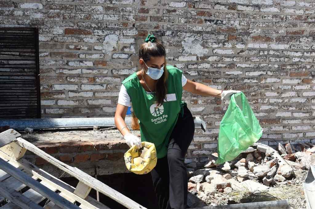 En plena acción. Una agente de promoción ambiental de las cuadrillas de higiene urbana retira un recipiente donde podría acumularse agua y