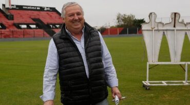 Con una sonrisa y con el rojo y negro de fondo