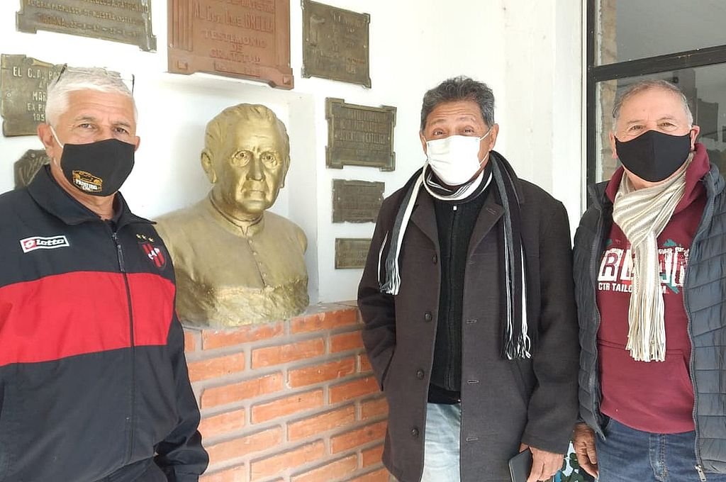 Lenzi junto a los históricos dirigentes Parkinson (izquierda) y González (derecha) y el busto del Padre Grella.