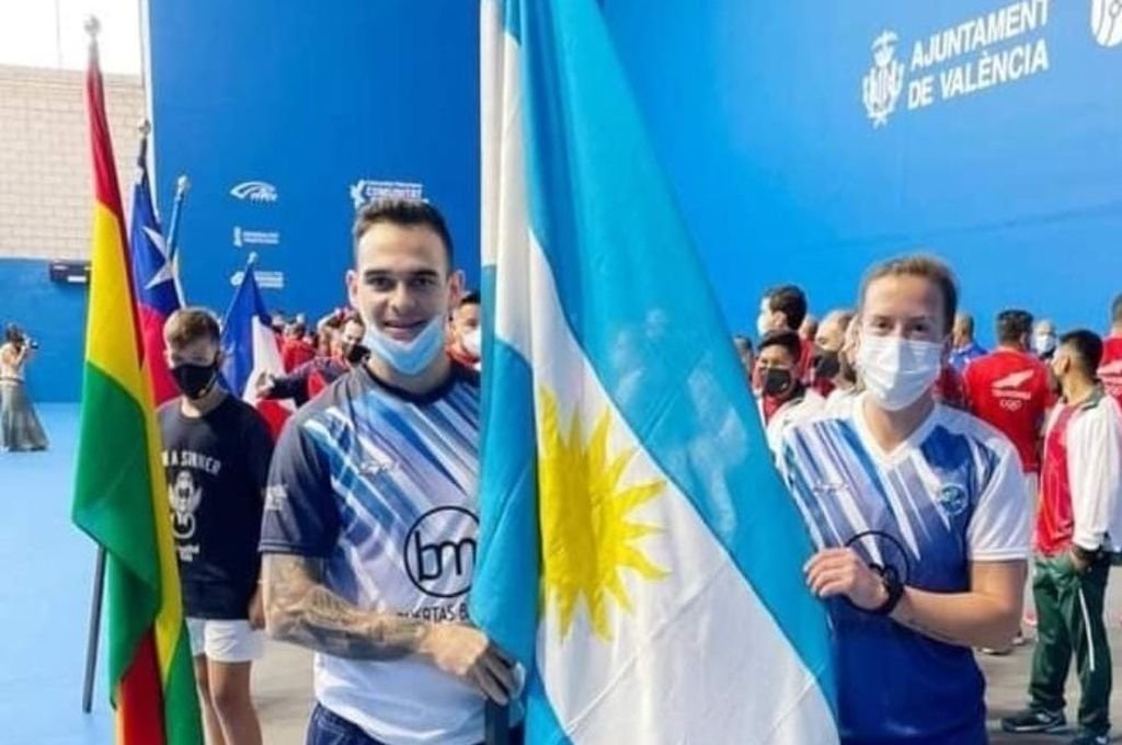 Melina Spahn y Alfredo Villegas portando la bandera nacional en Valencia.