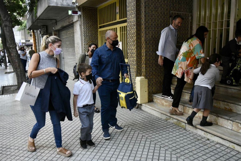 Un niño entra al Colegio Cristo Rey acompañado de sus padres. Marcelo Manera.