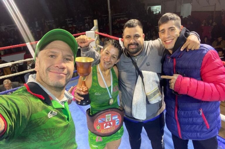 González posa con al cinturón y la copa. Junto a ella