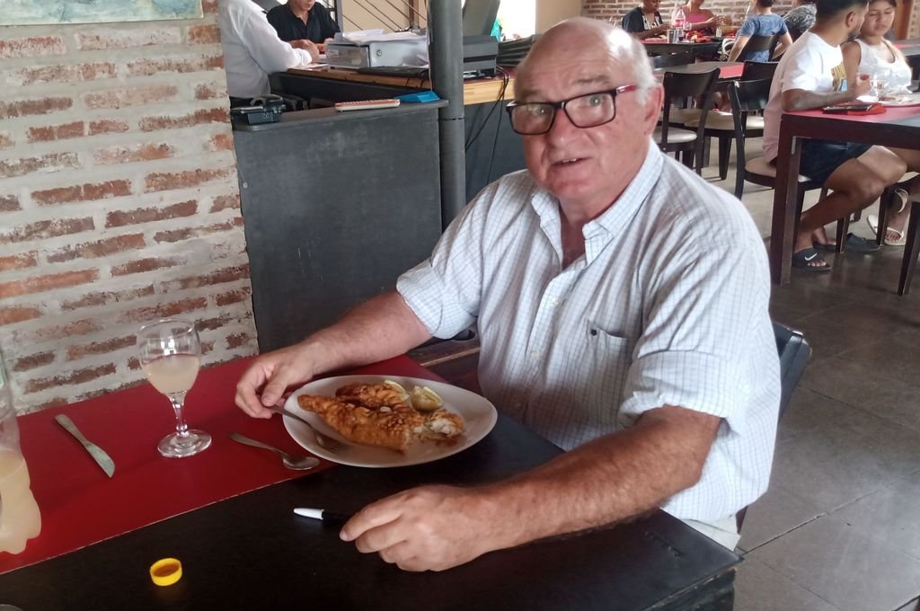 Cacho Carranza prueba una milanesa de surubí de su restaurante.