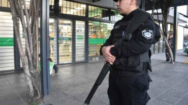 Un policía custodia la entrada del supermercado de Vicente López e Iturraspe. Pablo Aguirre.