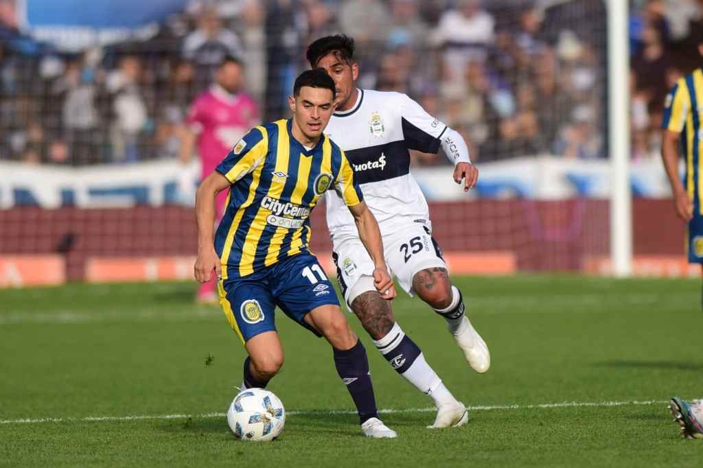 Maxi Lovera lleva la pelota perseguido por Cristian Tarragona