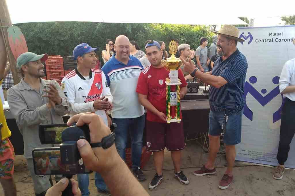 El intendente y el gerente de la Mutual entregan el trofeo a Facundo Führ