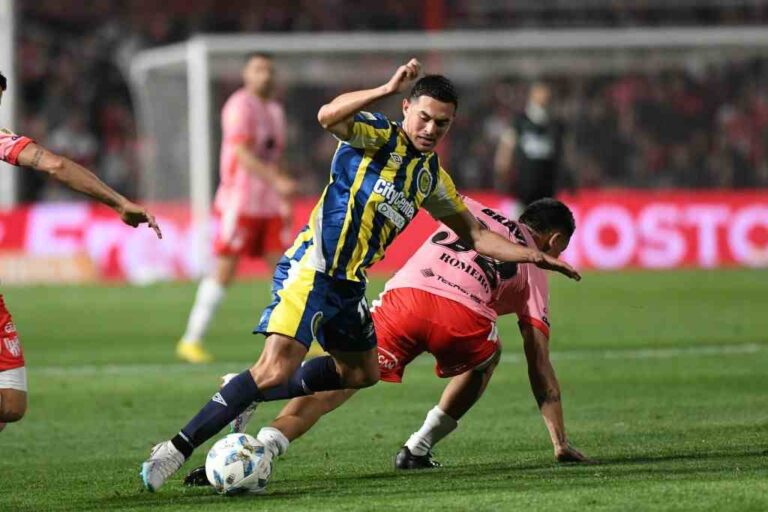 Lovera se lleva asediado por un rival. Gentileza: prensa Rosario Central.