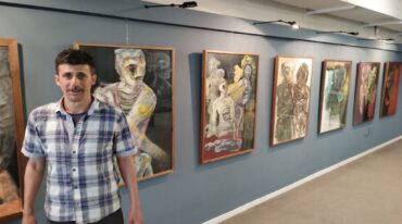 Germán Yujnovsky posa junto a sus obras en la Fundación Institucional.