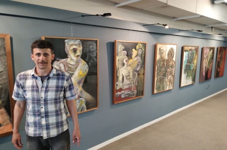 Germán Yujnovsky posa junto a sus obras en la Fundación Institucional.
