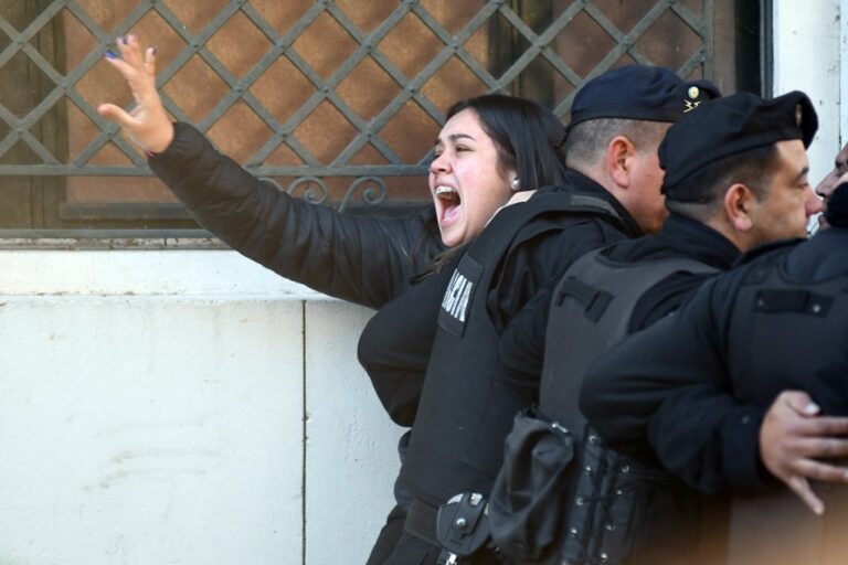 La policía cercó a quienes aguardaron a que retiraran a los condenados del edificio. Flavio Raina