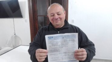 El padre Sergio Capoccetti sostiene la boleta más cara del servicio de energía eléctrica.  Gentileza.